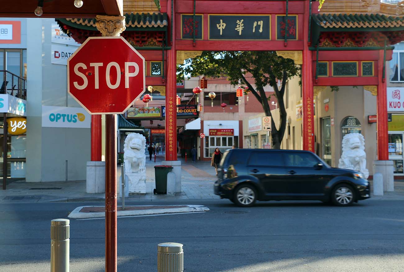 A street scene featuring a red octagonal stop sign mounted on a brown pole on the left side of the image.